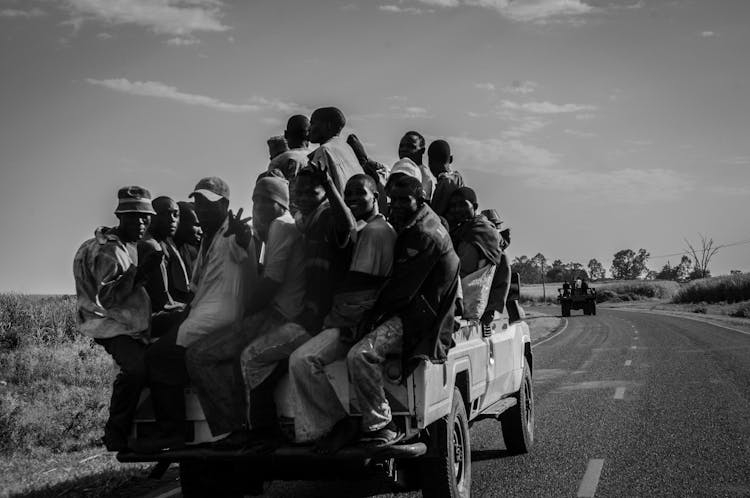 A Group Of Men Travelling In The Back Part Of A Pickup Truck