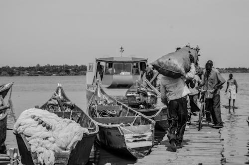 Busy People Walking on the Wooden Dock Near Fishing Boats