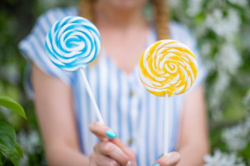 Free Close-Up Shot of Person Holding Two Lollipops Stock Photo