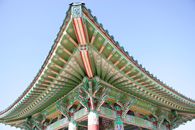 Intricate roof details of a traditional Korean building. Vibrant colors and patterns.