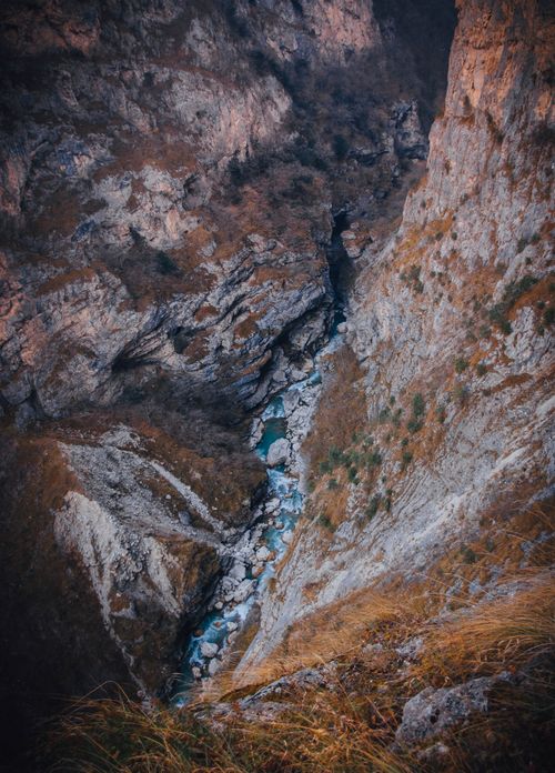 Free Stunning aerial shot of a rocky gorge with a flowing creek in a mountainous landscape. Stock Photo