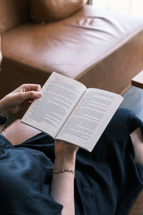 Free Close-up of hands holding a book in a cozy indoor setting, perfect for book lovers. Stock Photo