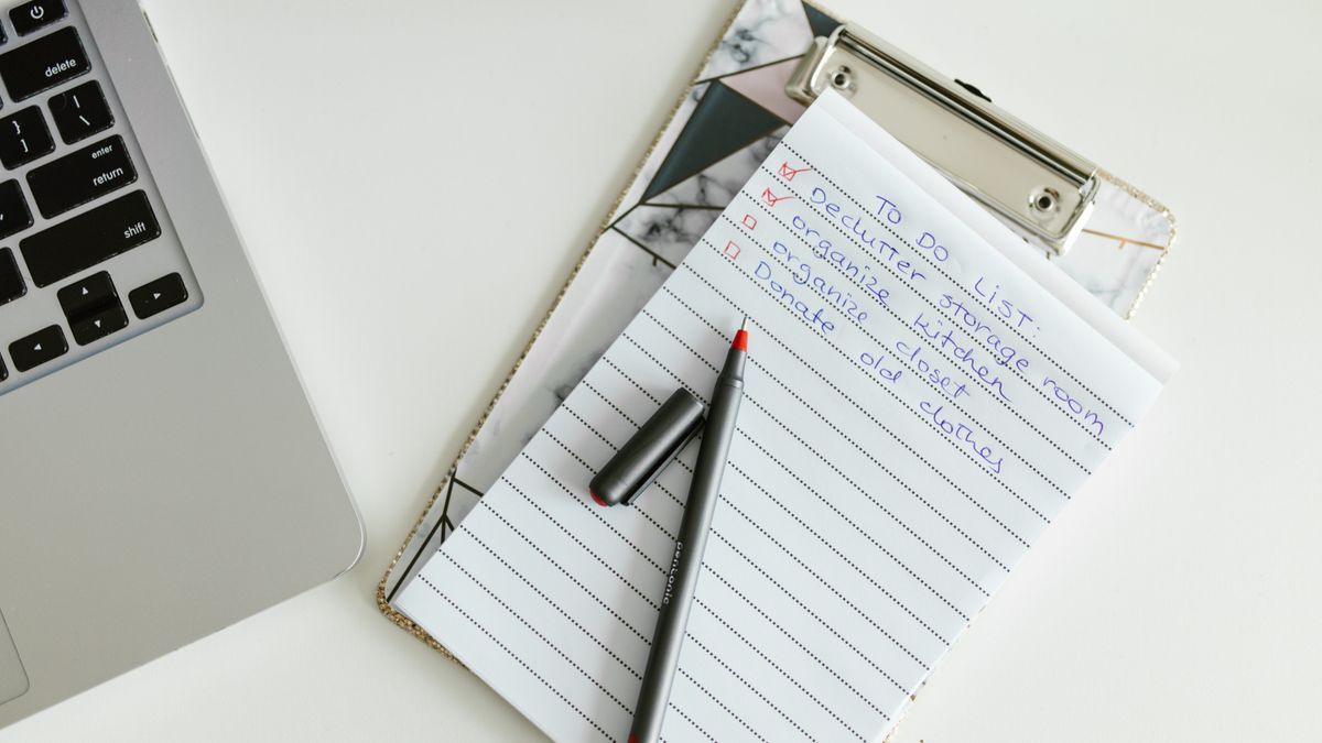 A neatly organized to-do list on a clipboard next to a laptop and pen, conveying productivity.