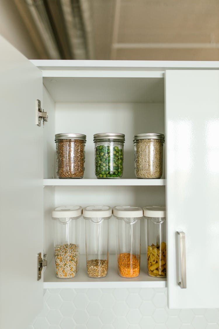 Clear Glass Jars On White Wooden Shelf