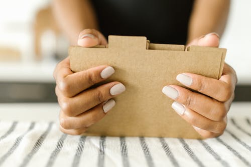 Person Holding Brown Cardboard Box