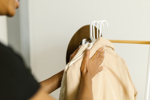 Free Close-Up Shot of a Person Arranging Clothes Stock Photo