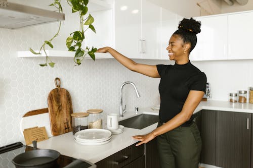 Free A Smiling Young Woman Organizing her Kitchen  Stock Photo