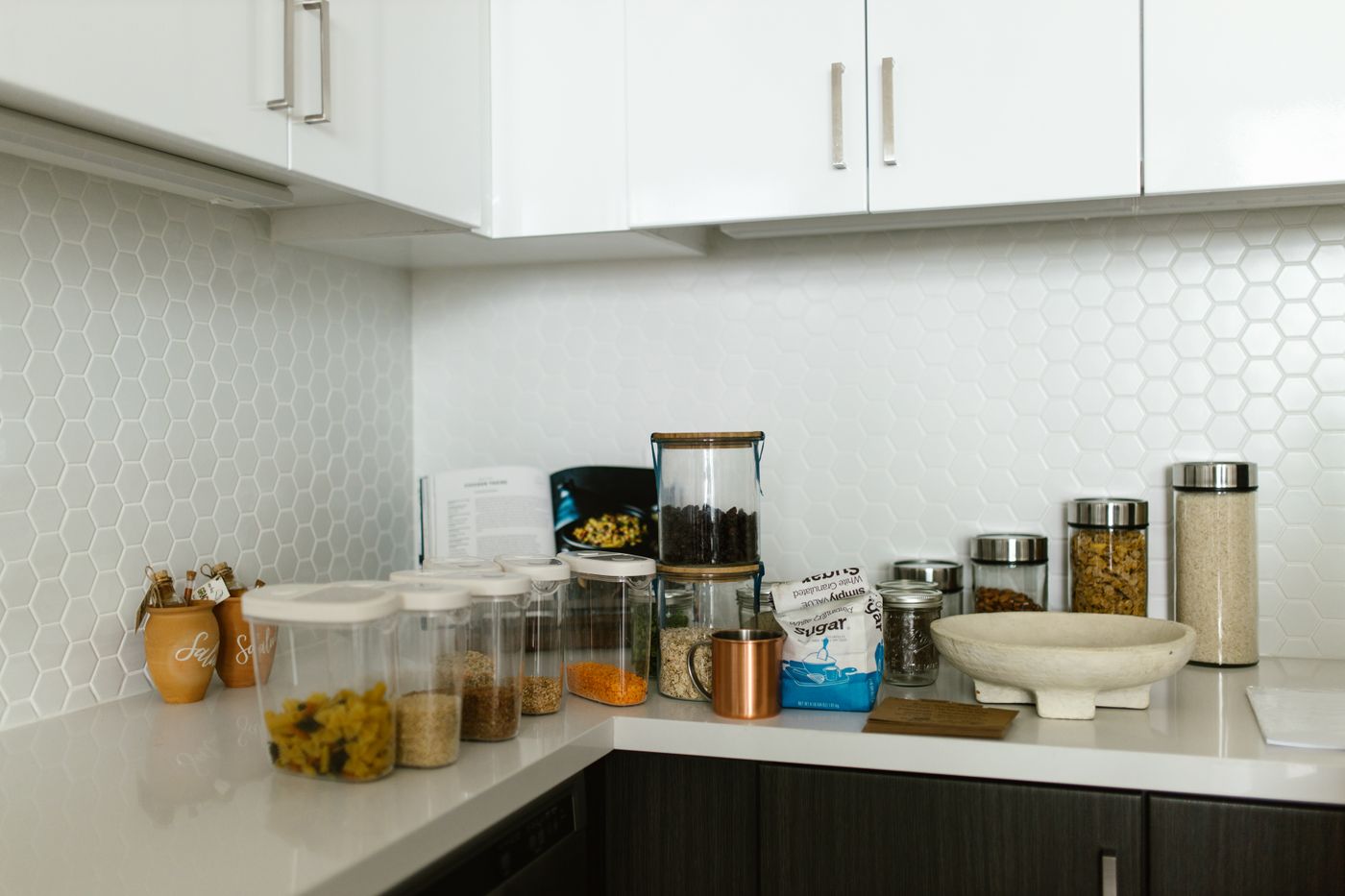 Neatly arranged food storage containers and glass jars on a clean kitchen countertop