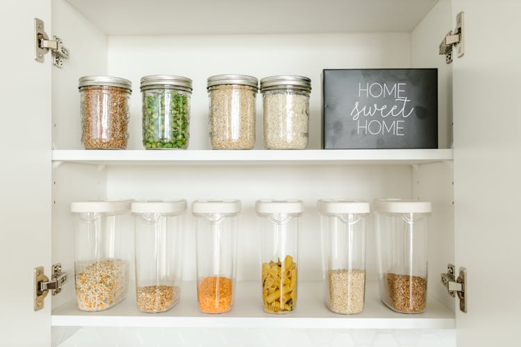 Clear Glass Jars On White Wooden Shelf