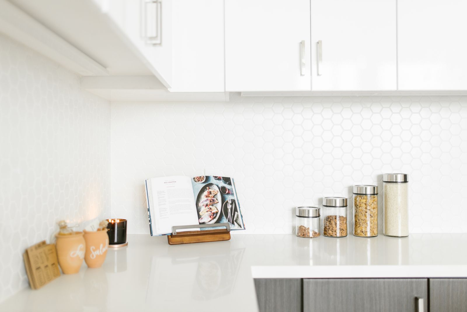 Minimalist pantry countertop with glass storage jars and open cookbook