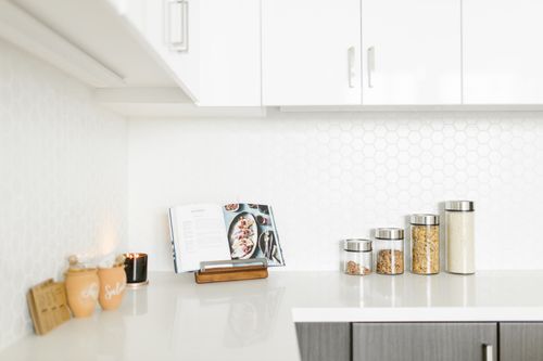 Free Bright minimalist kitchen interior showcasing decor and storage jars on a sleek countertop. Stock Photo