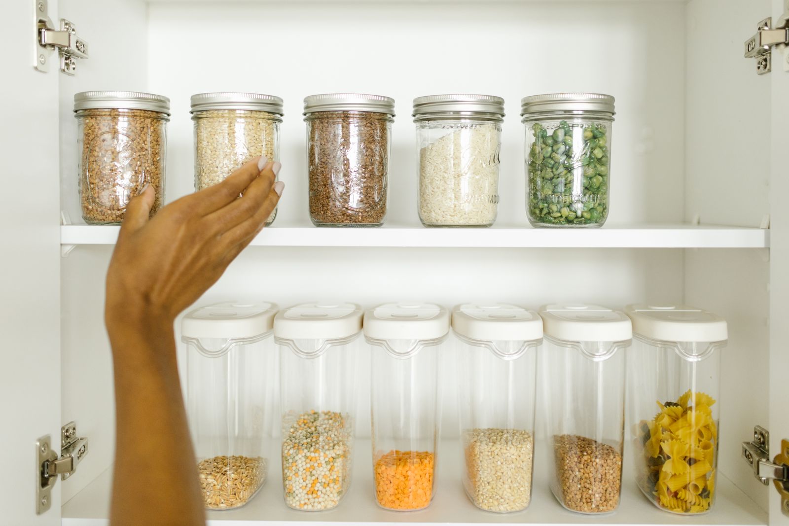 Organized pantry cabinet with clear containers and dry goods