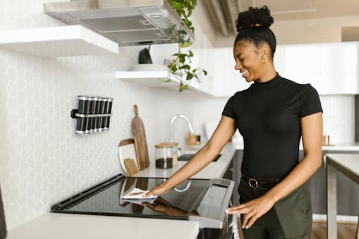 A woman is cleaning the kitchen stove top, showcasing modern housekeeping and responsibility.