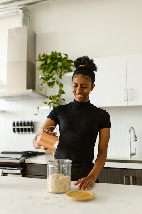 Woman pouring Dry Goods on a Glass Jar