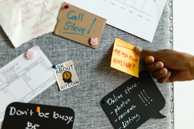 Close-up Photo Of Pinning Of Notes On A Gray Board 