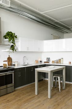A stylish, minimalistic kitchen featuring industrial design elements and modern furnishings.