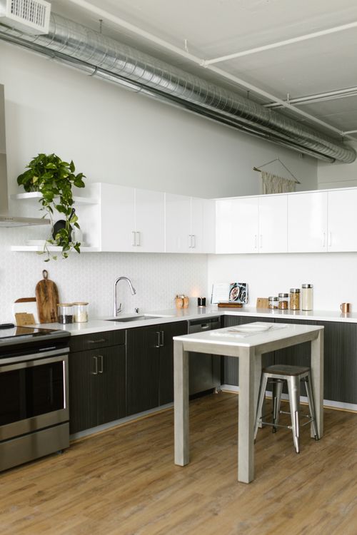 Free A stylish, minimalistic kitchen featuring industrial design elements and modern furnishings. Stock Photo