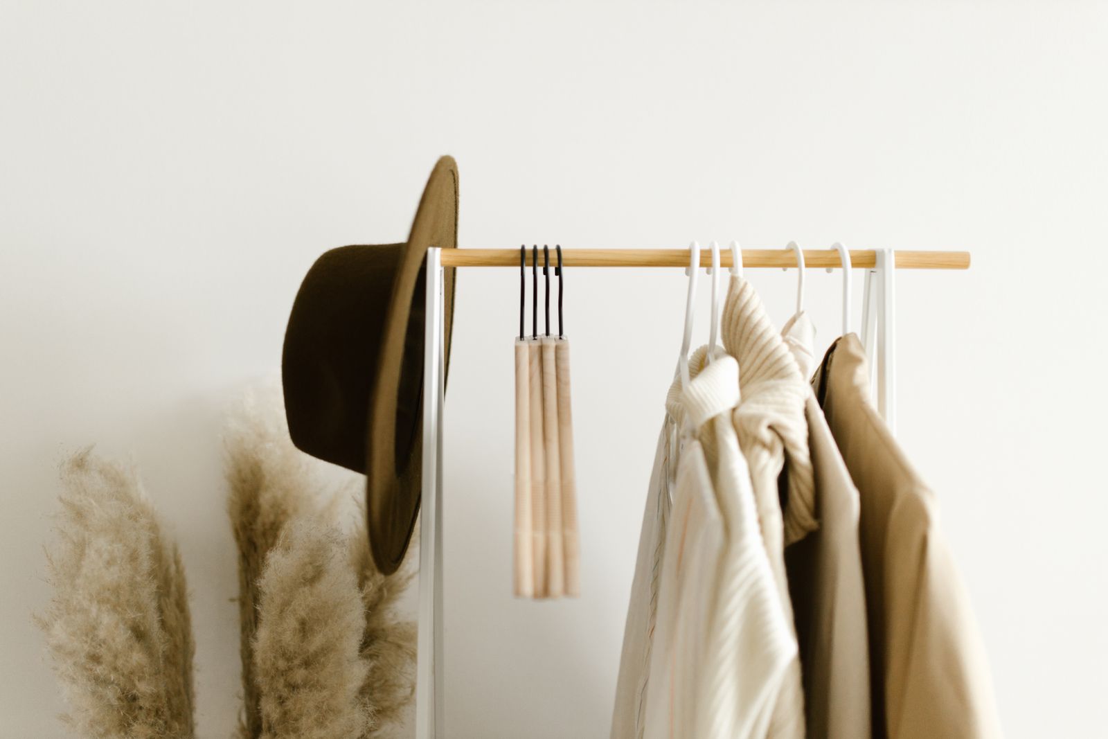 Minimalist clothing rack with neutral garments and hat