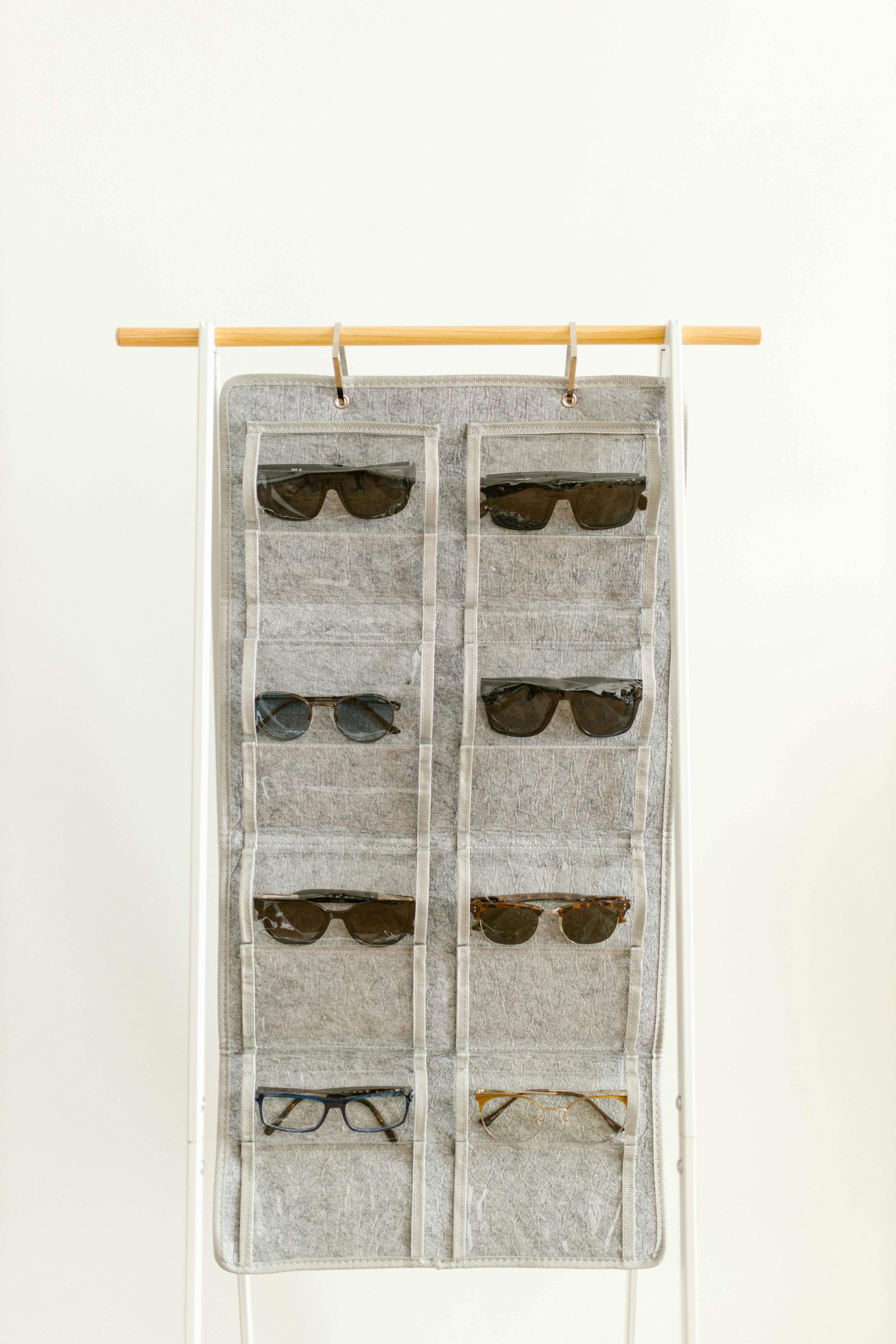 Close-up of a hanging organizer displaying various sunglasses and spectacles.
