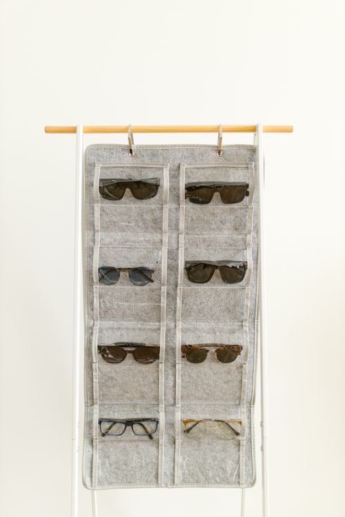 Small everyday items stored in the clear pockets of a hanging organizer