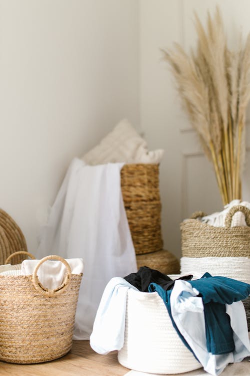 Free Clothes in Woven Baskets on a Wooden Floor Stock Photo