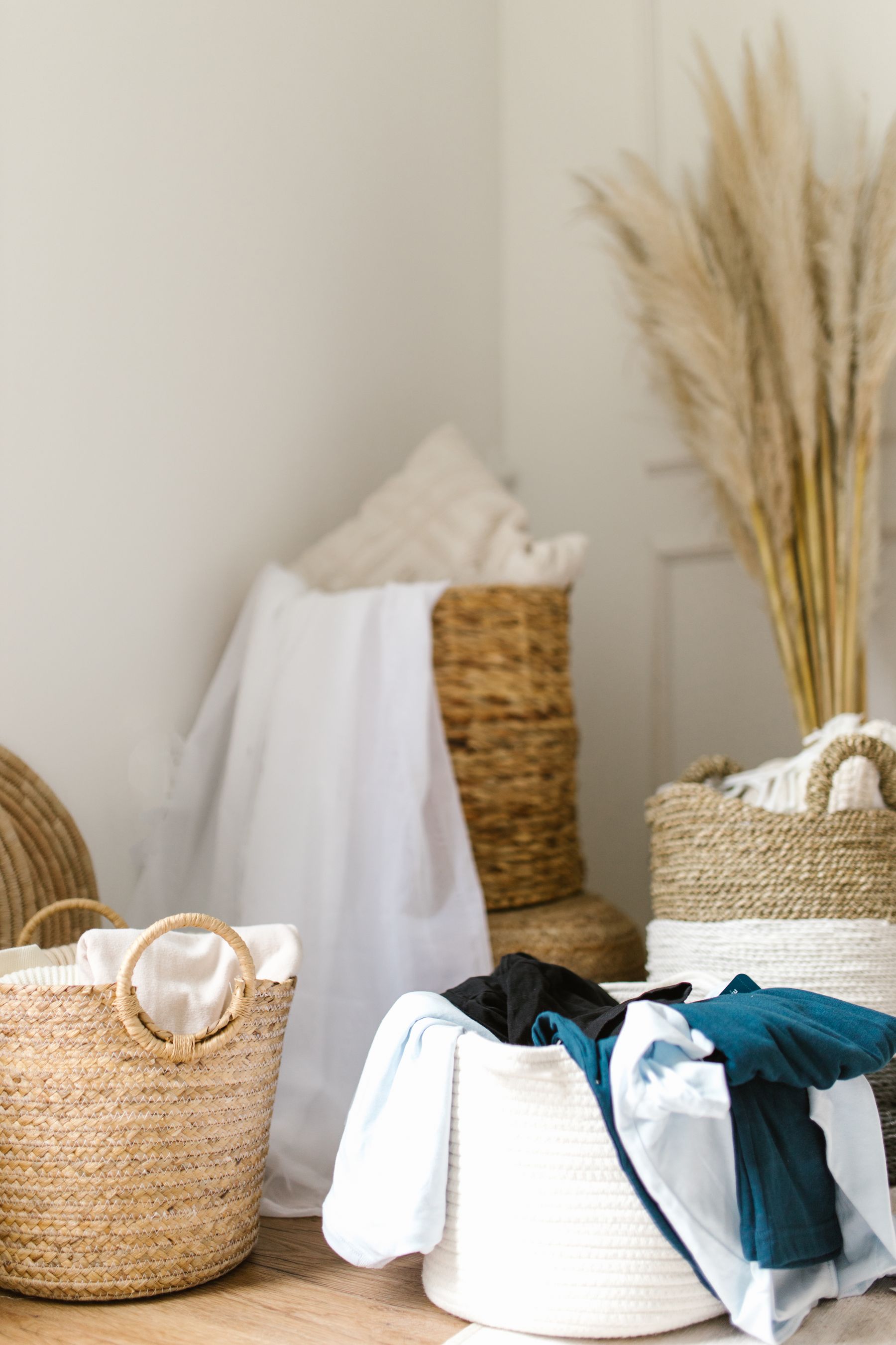 Woven laundry baskets holding sorted light and dark clothing in a calm home laundry area