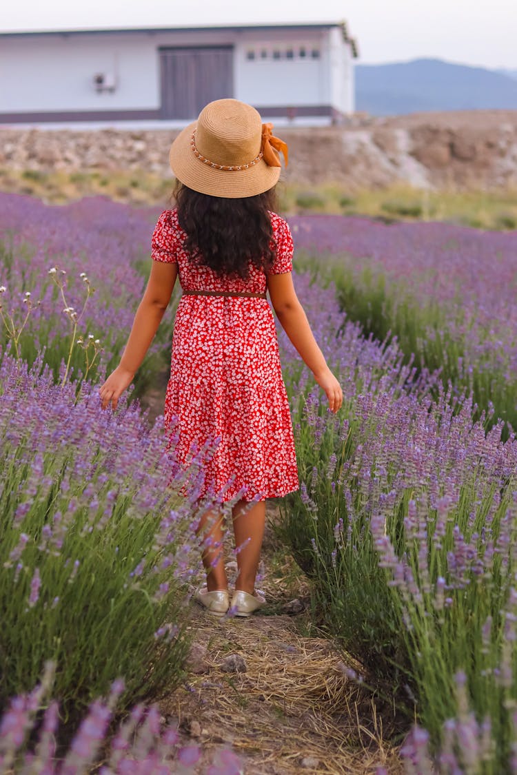 A Woman Wearing A Red Floral Dress And Sunhat