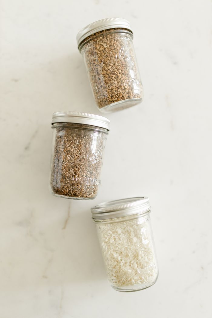 Glass jars of grains and rice on a pale marble counter, photo by RDNE Stock project on Pexels
