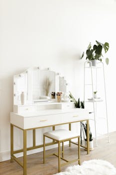 A minimalist vanity table with lights and plants for a serene and organized space.