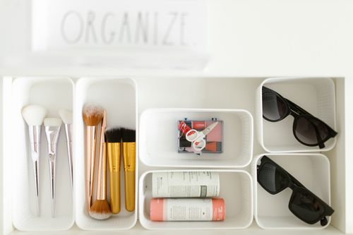 Free Flat lay of cosmetics and accessories neatly organized in white trays on a white background. Stock Photo