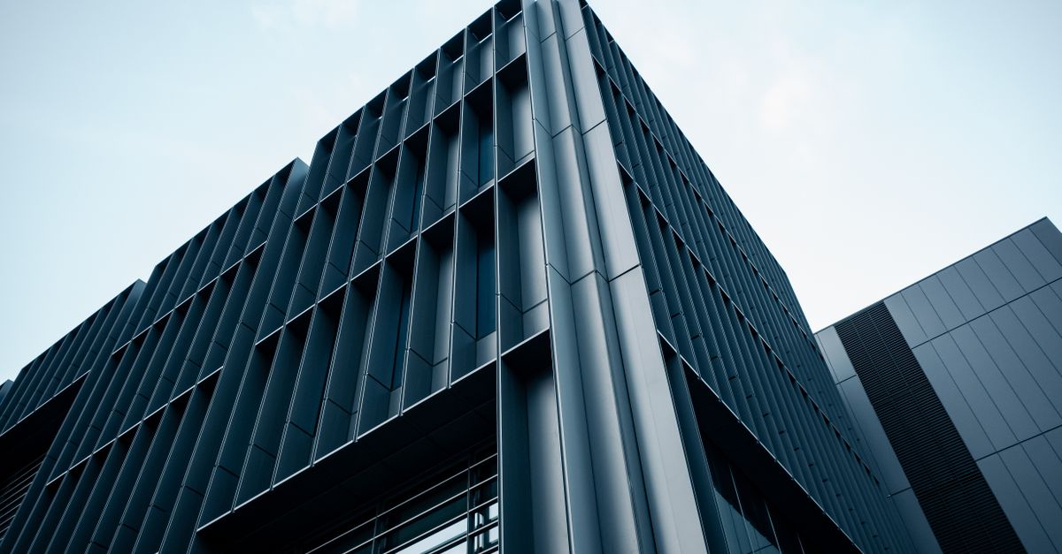 Low-angle view of a contemporary high-rise building showcasing a geometric facade and sleek design.