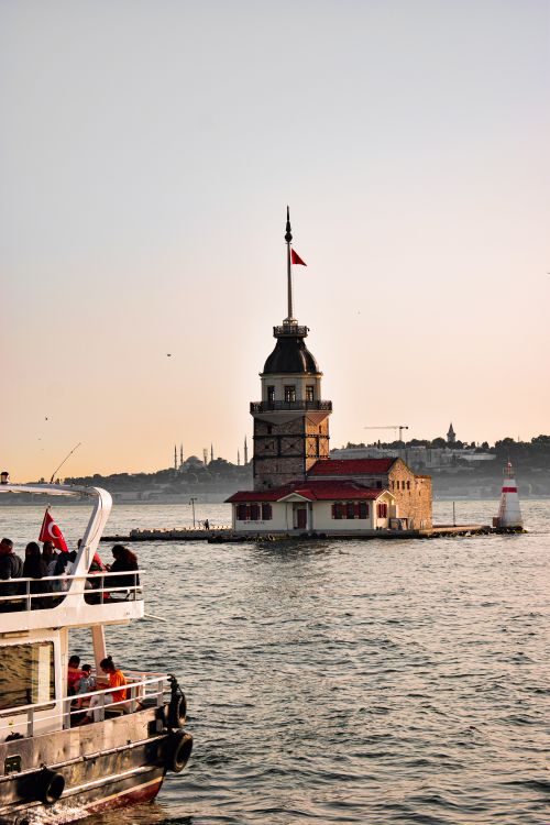 Free A serene view of Maiden's Tower on the Bosphorus, Istanbul, with a ferry in the foreground. Stock Photo
