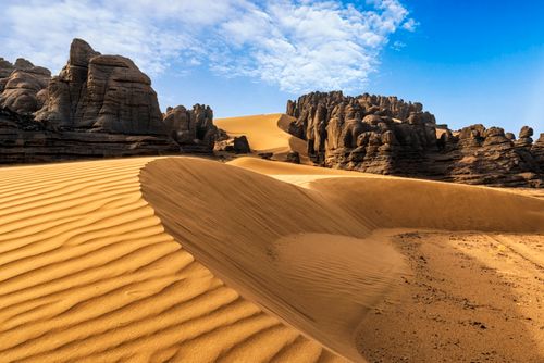 Free Breathtaking view of sand dunes against rocky formations in Algeria's Sahara desert. Stock Photo