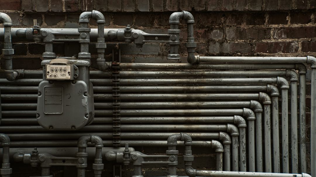 Service pipework overhead in an industrial building. What it carries is set by the headcount, not by the drawing.