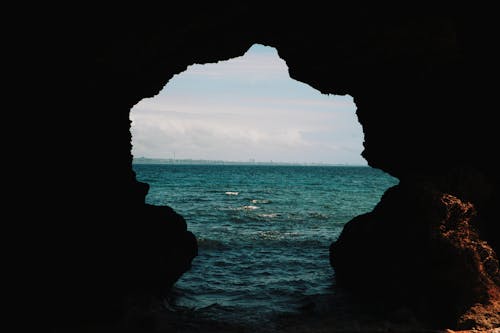 Free Cave Opening on a Body of Water Stock Photo