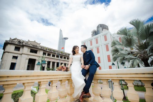 A Newly Wed Couple Posing on the Balcony Railing