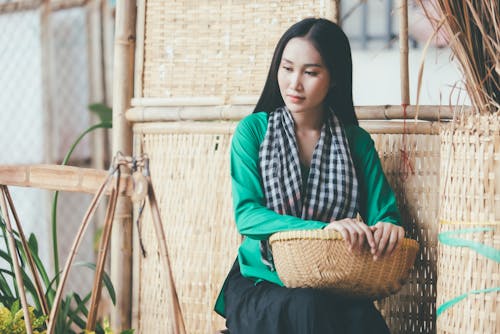 Young Woman Sitting and Holding a Basket 