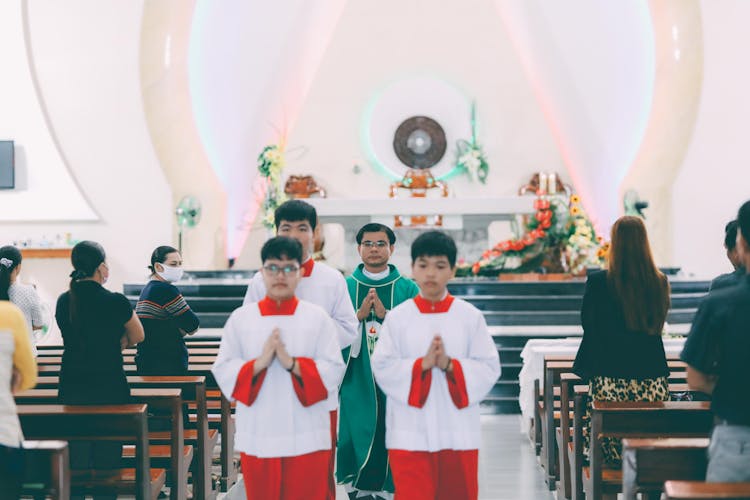 Priest And Altar Servers Performing Christian Ceremony In Church