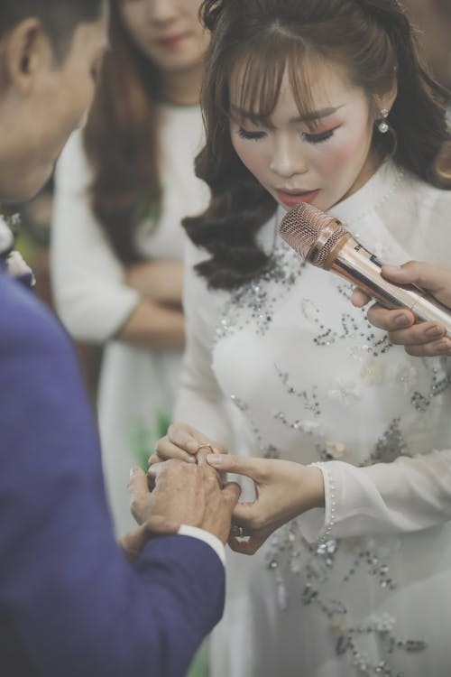 Free A Bride Making a Vow while Inserting the Ring on Her Husband's Finger Stock Photo
