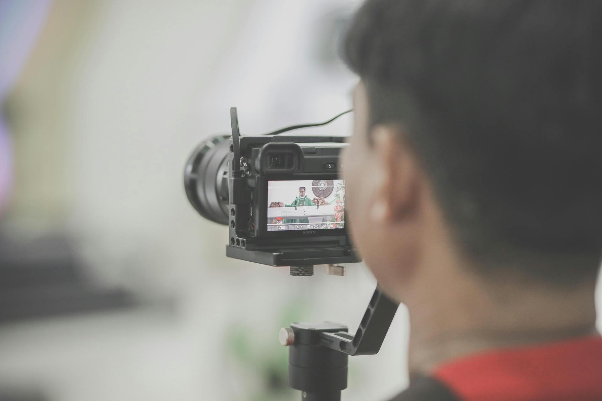 Close-up of a photographer capturing an event indoors with a professional camera setup.