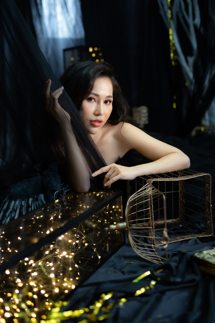 Stunning portrait of a woman with dark background and decorative lights, exuding elegance.