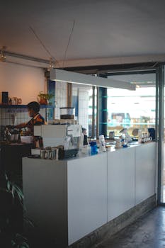 Warm and inviting interior of a coffee shop featuring a barista at work behind the counter.