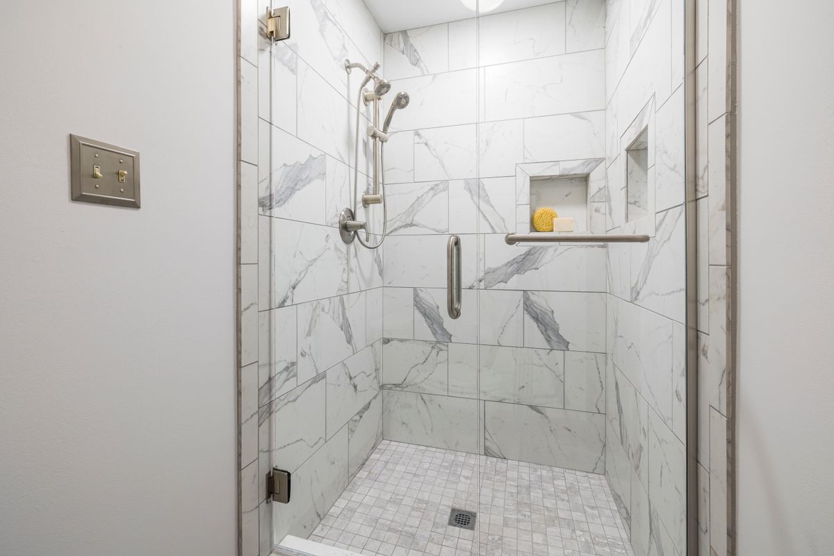 neutral tiled modern wet room with glass screen