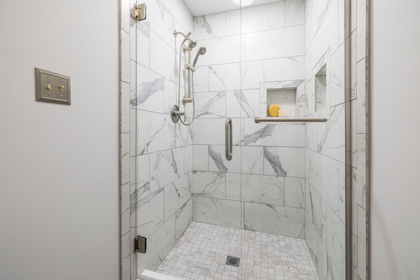 Bathroom with white marble tiles and glass shower door