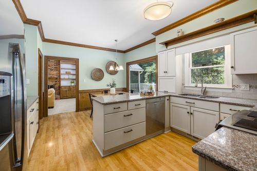 Free Spacious modern kitchen with granite countertops and hardwood floors, featuring large windows and natural light. Stock Photo