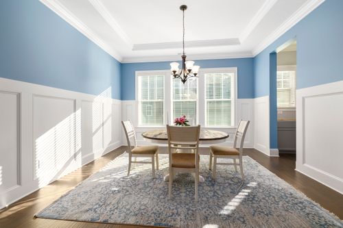 Free Bright dining room with blue walls, elegant decor, and abundant natural light. Stock Photo