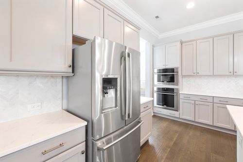 Free Contemporary kitchen design featuring stainless steel refrigerator and built-in ovens for a sleek look. Stock Photo