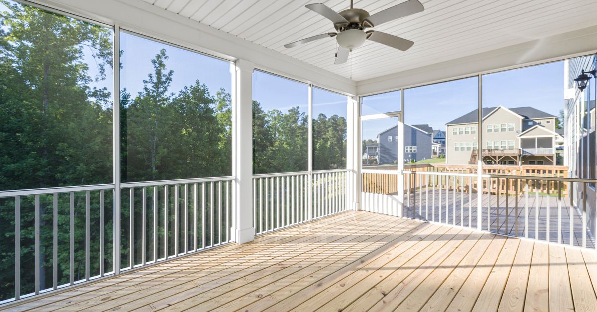 Bright and airy wooden porch with clear glass windows in a suburban setting.