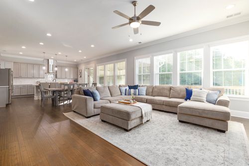 Free Bright, open-plan living room with a modern kitchen, featuring comfortable seating and natural light. Stock Photo