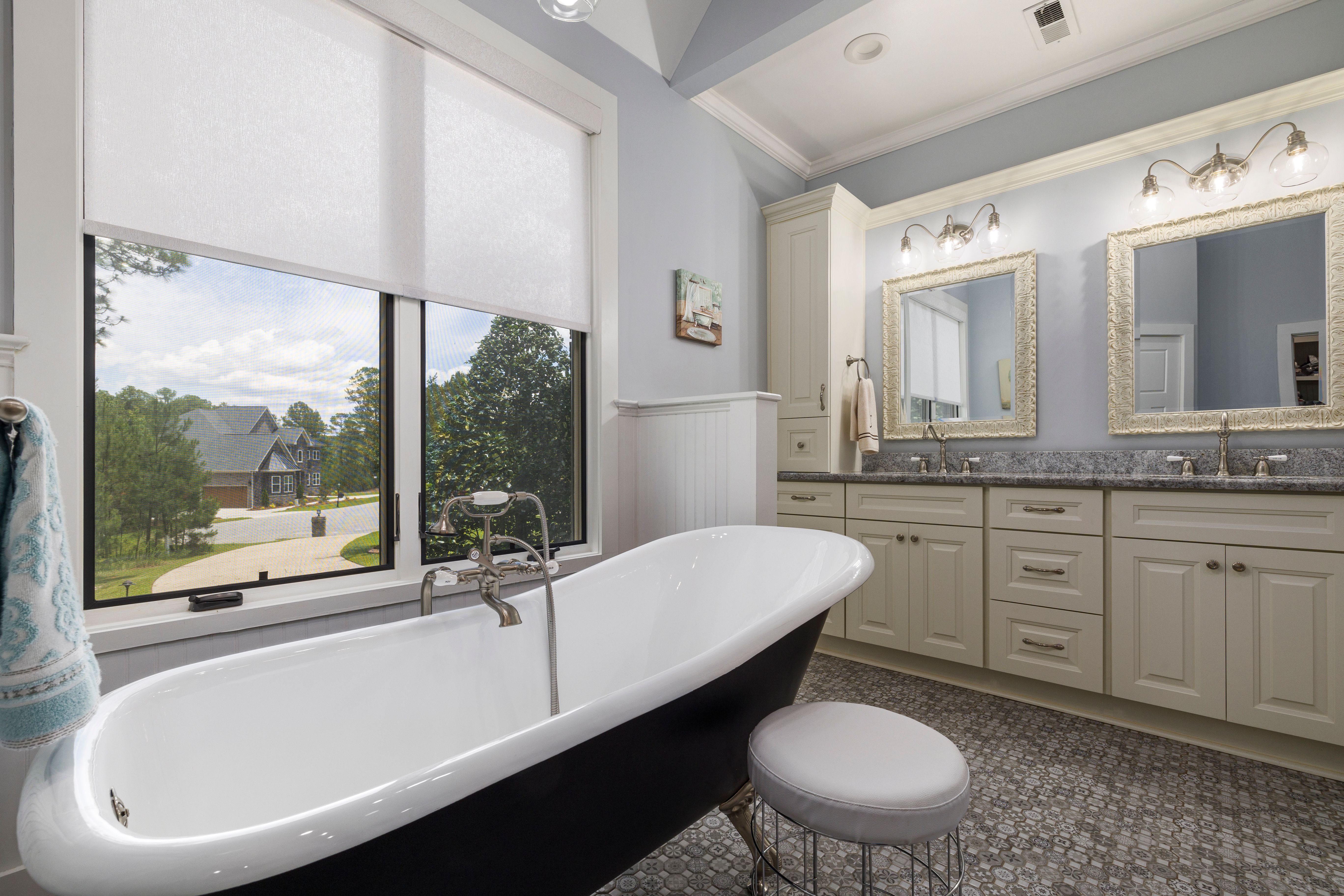 Free Elegant bathroom featuring a freestanding tub and double vanity with outdoor view. Stock Photo